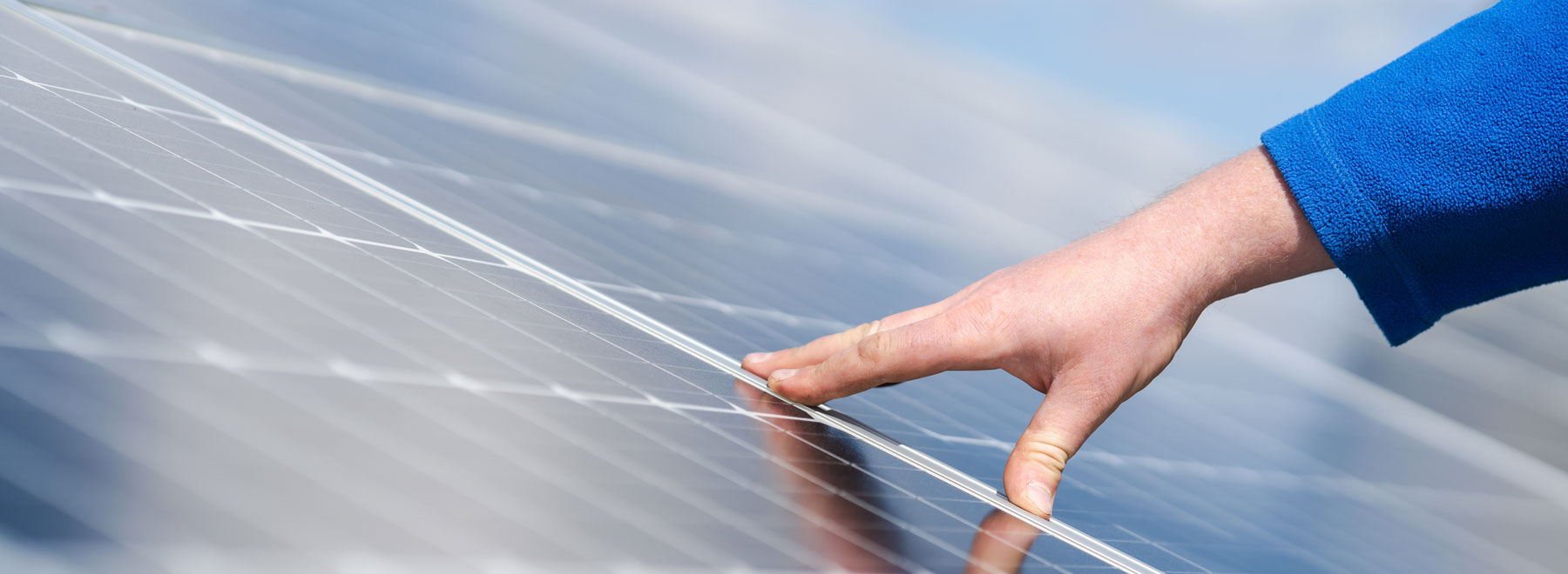 Hand berührt Solarmodul von Enelhardt Energieberater in Hohenstein in Sachsen